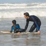 Beach Guides - Man Teaching a Boy How to Surf