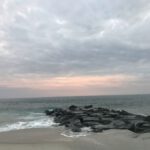 Cape May - black rocks on seashore under cloudy sky during daytime
