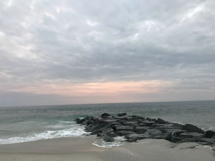 Cape May - black rocks on seashore under cloudy sky during daytime