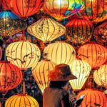 Culture - Two Person Standing Near Assorted-color Paper Lanterns