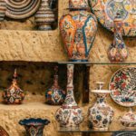 Local Crafts - Collection of various decorative ceramic plates and vases placed on rough stone wall and floor